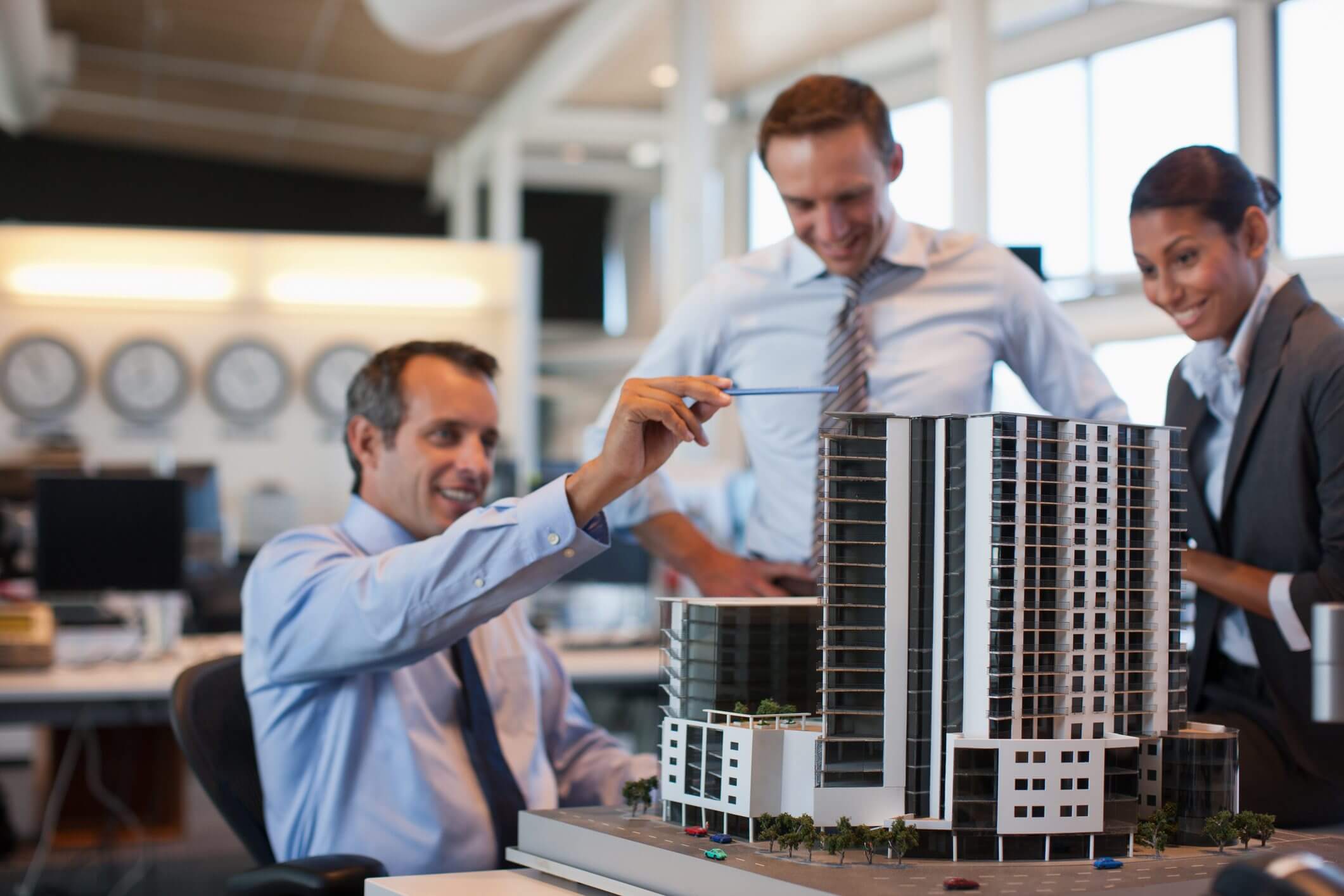 Two businessmen discussing a building model in a bright office.