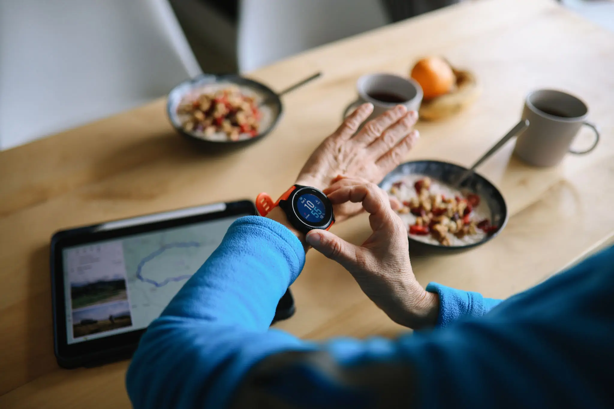 Person checking smartwatch while eating breakfast cereal.